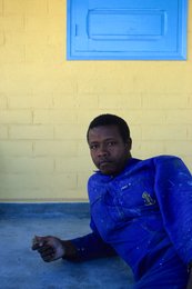 Archipel-des-Comores;-Bleu-de-travail;-France;-Jeune-homme;-Kaleidos;-Kaleidos-images;-La-parole-à-limage;-Laurent-Abad;-Mayotte;-Mur-jaune;-Océan-Indien;-Peinture;-Portrait;-Stories-Pictures;-Travail
